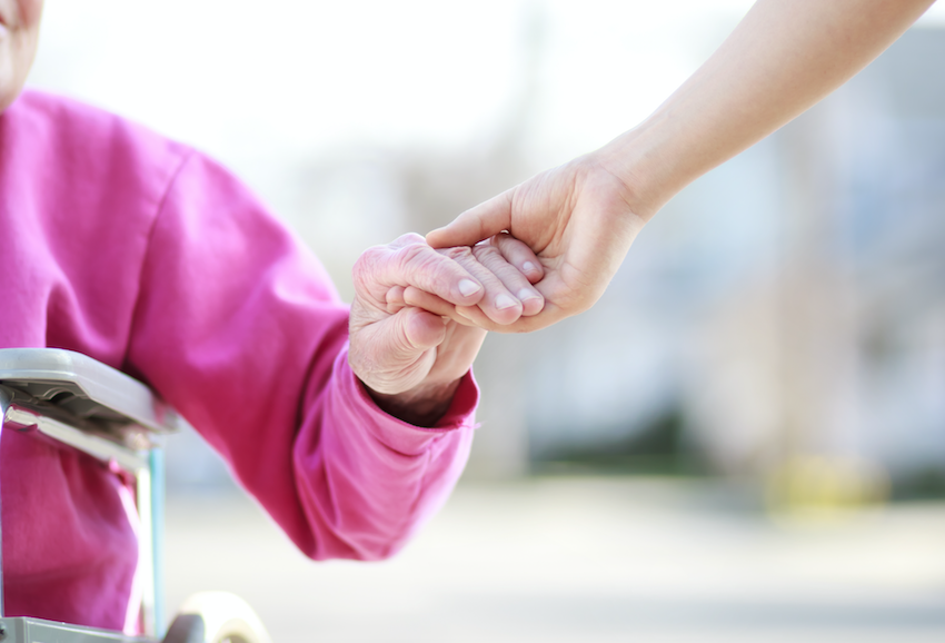 Senior residential care: Elderly lady holding hands with young carer